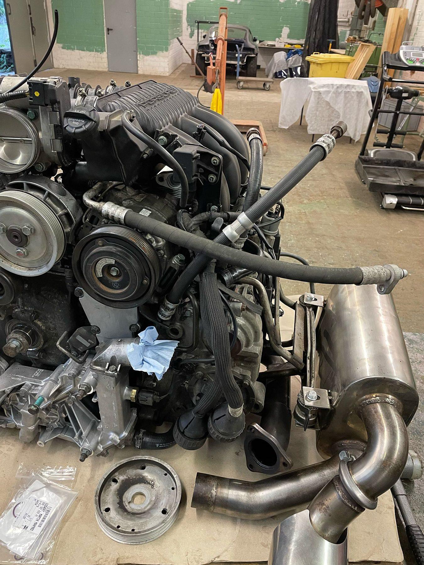 Ausgebauter Boxermotor mit Nebenaggregaten und Abgasteilen in der Werkstatthalle
