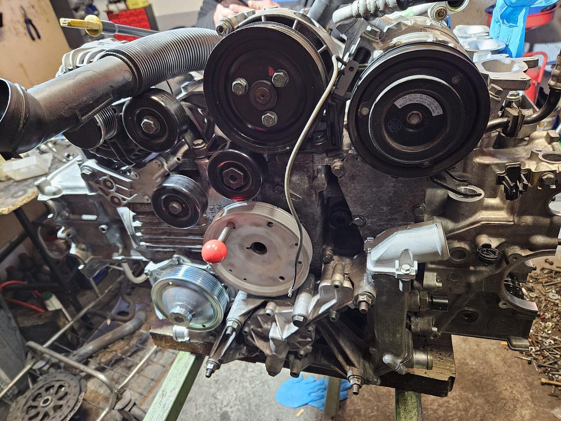 Vorderseite eines ausgebauten V-Motors mit Riemenscheiben und Nebenaggregaten